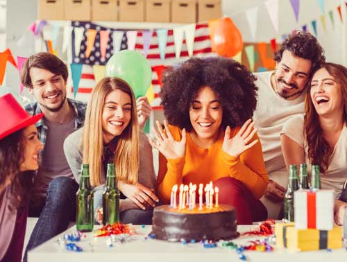 A fun group of friends celebrating around a birthday cake
