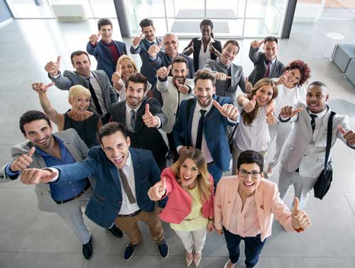 A group of engaged employees give thumbs-up to the camera